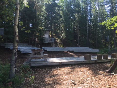 OUTDOOR AMPHITHEATER & FIRE PIT  This area has fire pit, benches and a stage.  Electrical plugins are there to plugin your sound system.  Firewood available on request.
